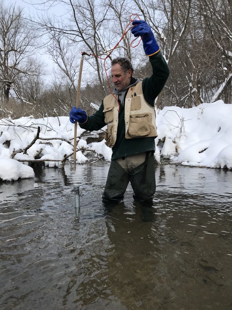 Tony Runkel performing field work in a stream during the winter.